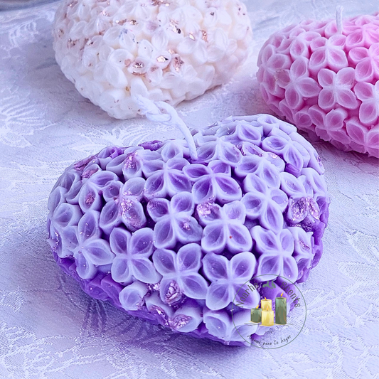 La vela perfecta para los enamorados, encenderá los sentidos con su encanto. Su delicada forma de corazón, decorada con pequeñas flores y chispas de pan de oro, la convierte en el complemento perfecto de veladas mágicas y románticas.
Puedes personalizarla en el color que prefieras, con o sin aroma.