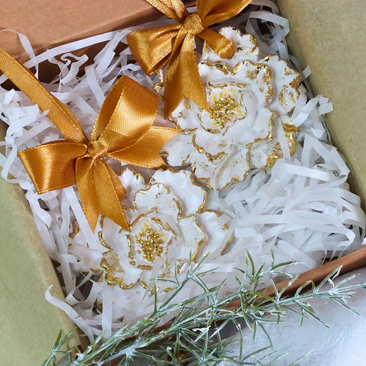 Perfuma tu espacio y tu ropa con un toque de elegancia y frescura gracias a nuestro perfumador artesanal. Cada pieza está hecha a mano en nuestro taller, utilizando resina acrílica biodegradable y decorado con pan de oro y personalizada con una&nbsp;delicada cinta de satén del color que mas te guste, creando un accesorio que no solo perfuma, sino que también embellece tu entorno.